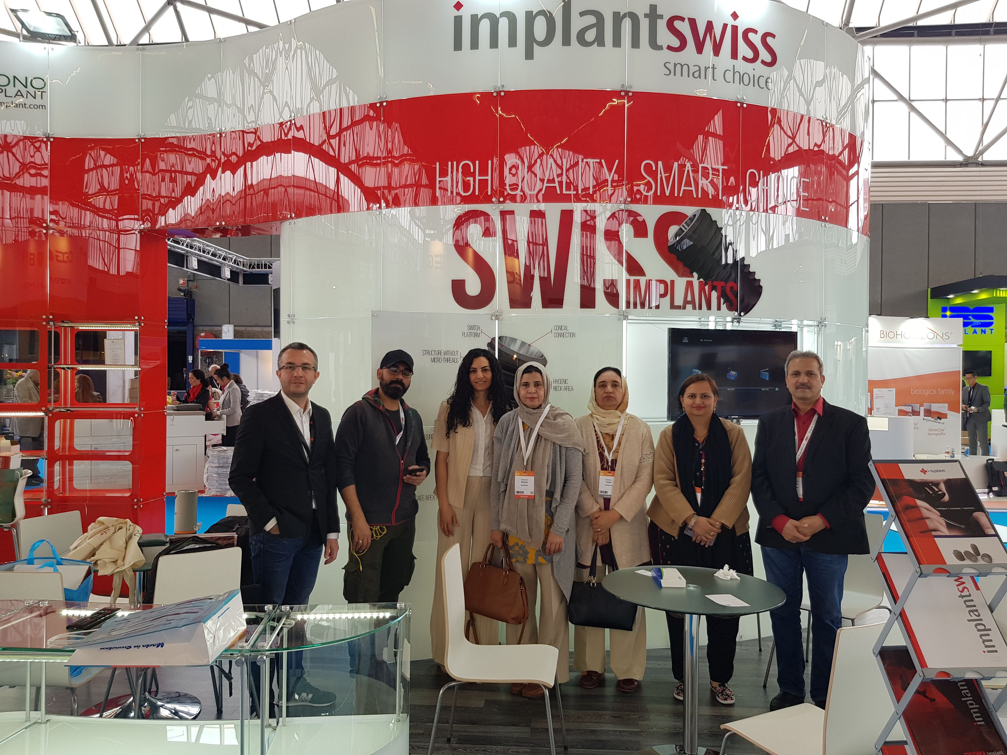 A group of dental professionals at an international dental implant exhibition stand
